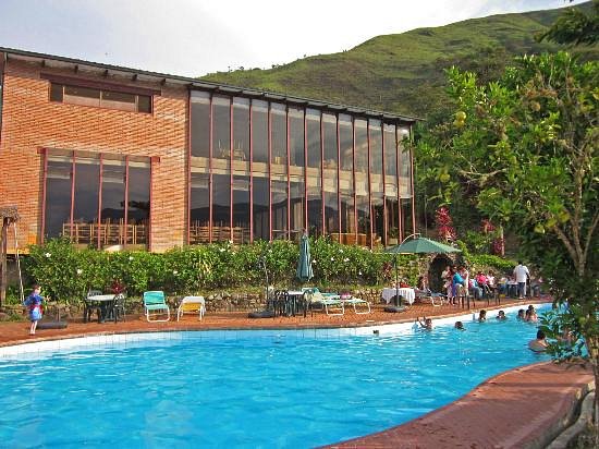 Huéspedes disfrutando de la piscina junto al edificio principal